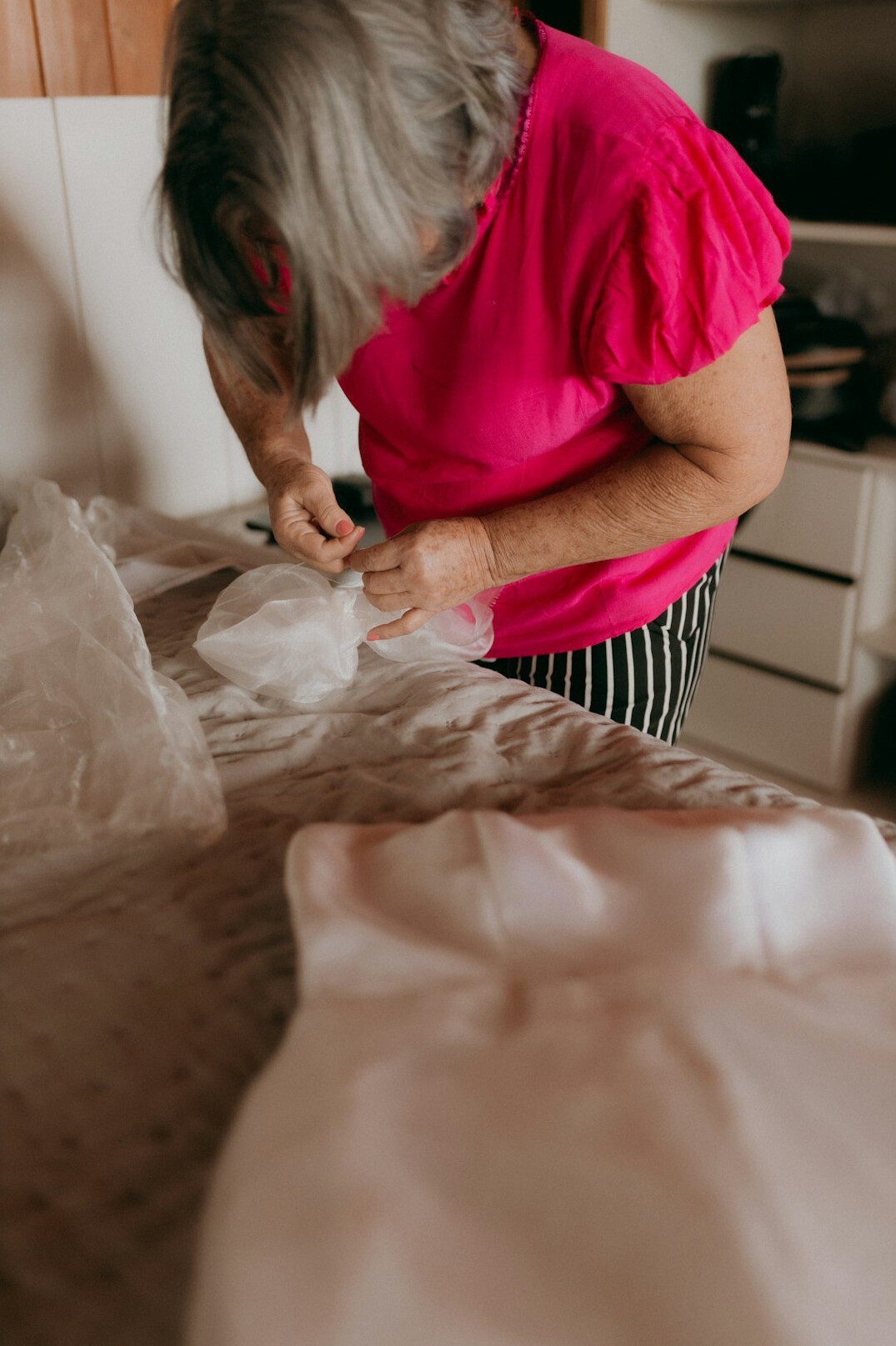person making bed in morning